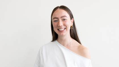 Woman with long dark hair smiles open mouthed at the carmera