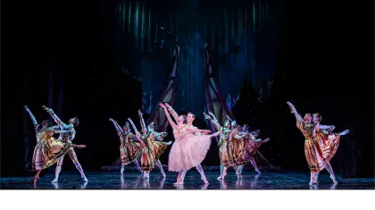 The group all in unison dancing at the final ball, in front the Prince and Cinderella