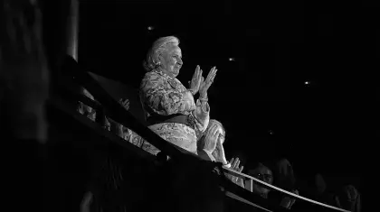 Distinguished woman standing, clapping on a theatre circle